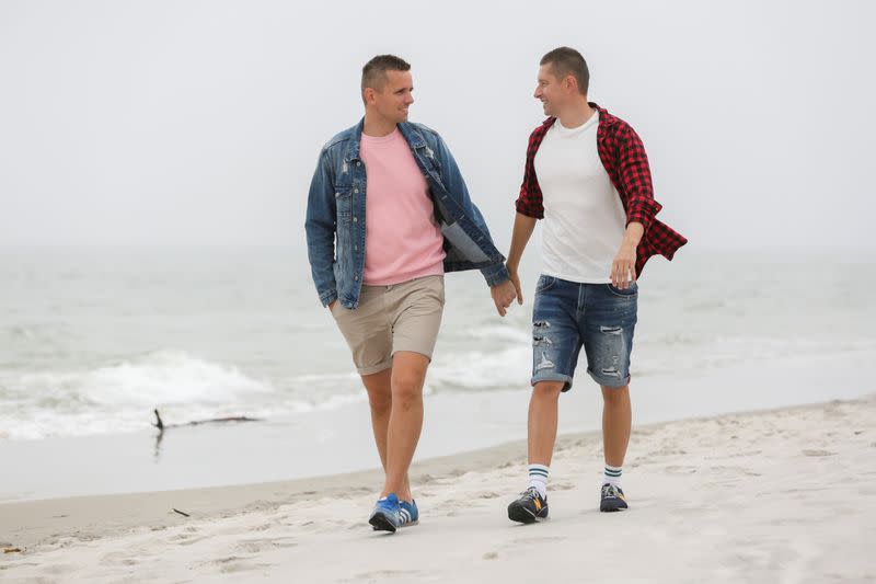 Gay married couple Dawid Mycek and Jakub Kwiecinski walk on the beach in Hel