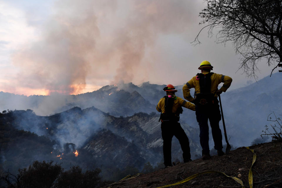 Firefighters work on a fire line as flames from the Palisades Fire glow in the distance in Topanga State Park, northwest of Los Angeles, on May 15, 2021. (Patrick T. Fallon / AFP - Getty Images)