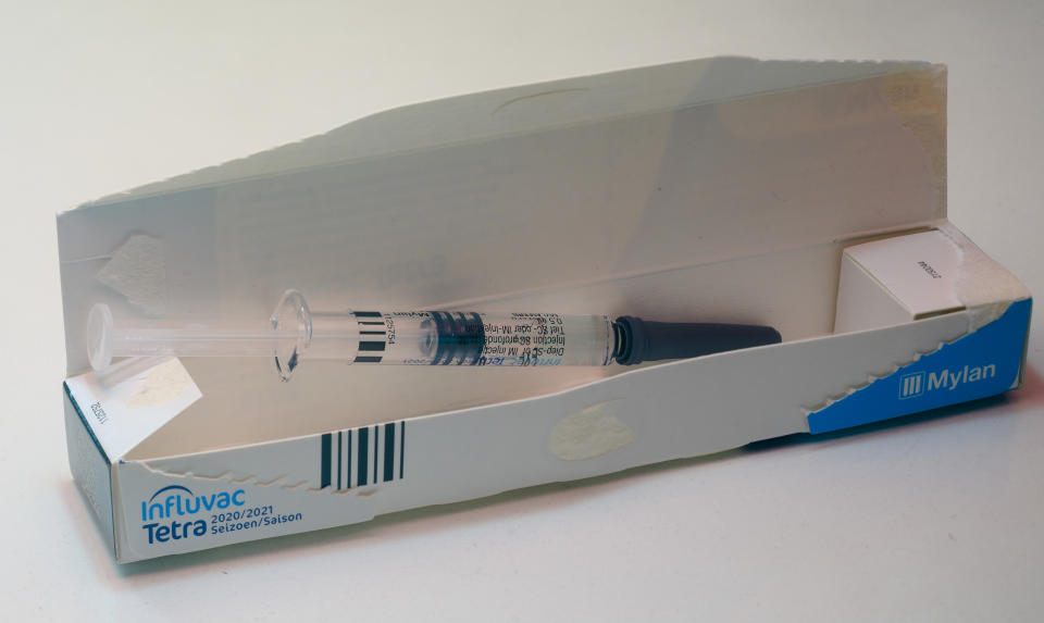 A Flu Vaccine Syringe Rests On A Table