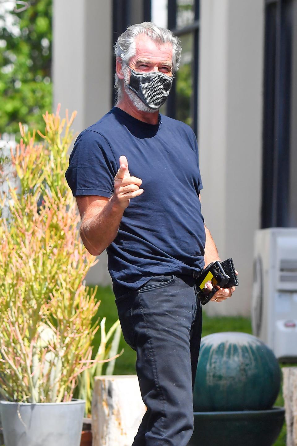 <p>Pierce Brosnan gets playful with the cameras on Sunday while arriving to a studio in L.A. </p>