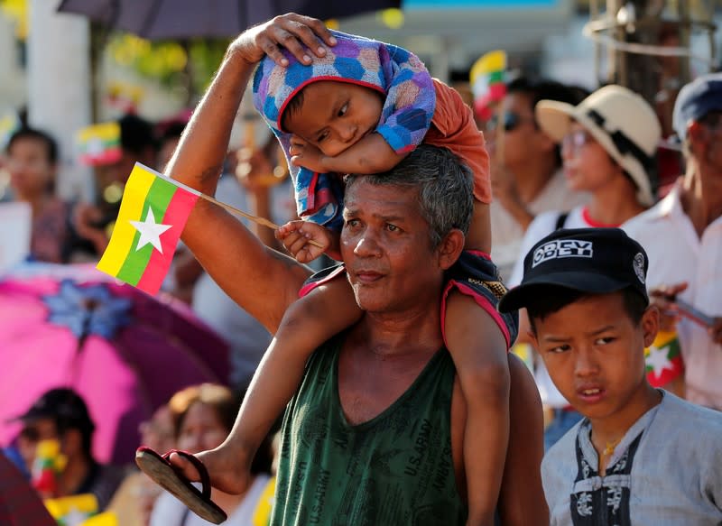 People gather to rally in support of Myanmar State Counsellor Aung San Suu Kyi before she heads off to the International Court of Justice (ICJ), in Yangon