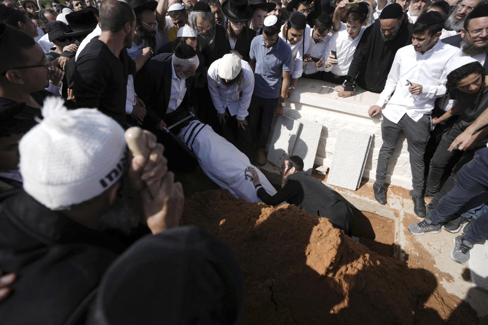 Yonatan Havakuk is buried in Petah Tikva, Israel, the day after he was killed with two others in a stabbing attack in Elad, Friday, May 6, 2022. Israeli security forces waged a massive manhunt Friday for two Palestinians suspected of carrying out the stabbing attack on Thursday near Tel Aviv that left three Israelis dead.(AP Photo/Ariel Schalit)