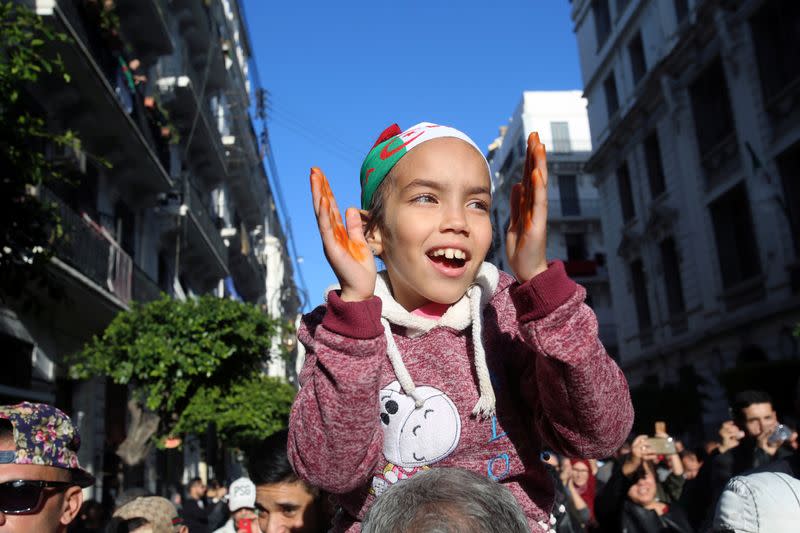 A child gestures as people take part in a protest to demand for the presidential election scheduled for next week to be cancelled, in Algiers