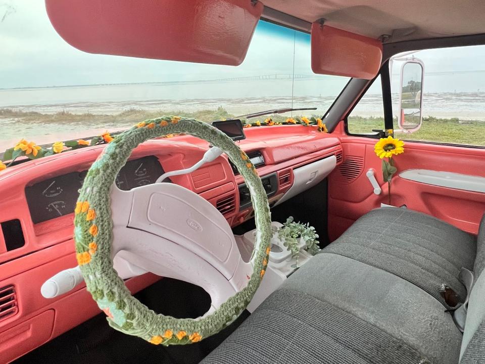 The steering wheel is decorated with a floral crochet cover.