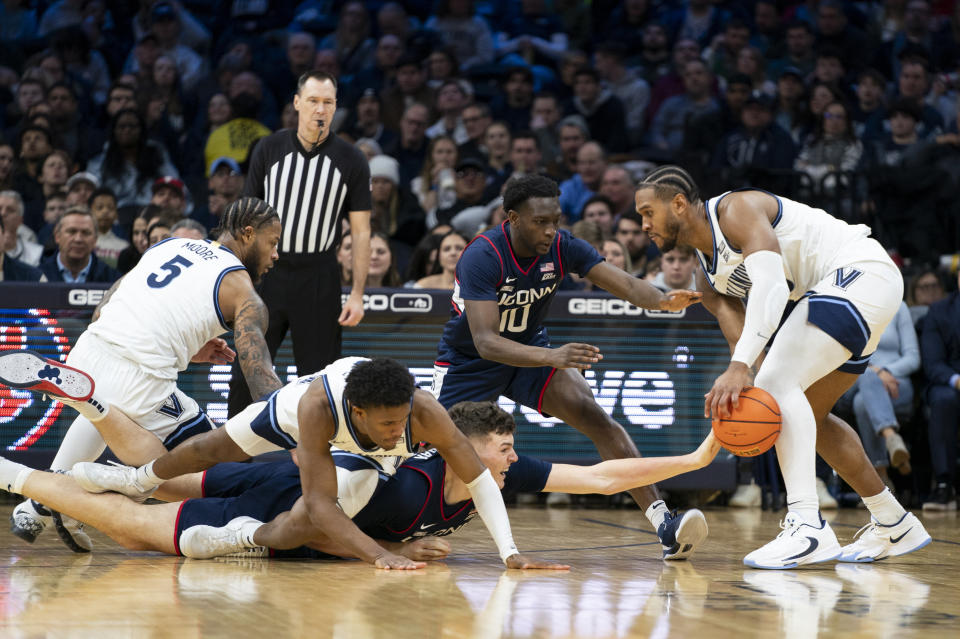 Villanova's Eric Dixon, right, grabs the ball before UConn's Hassan Diarra, center right, and Donovan Clingan, center, can get it during the second half of an NCAA college basketball game Saturday, Jan. 20, 2024, in Philadelphia. (AP Photo/Chris Szagola)