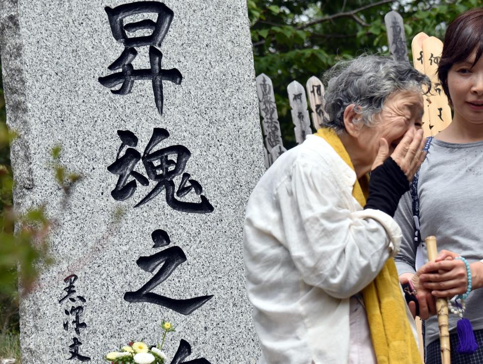 Relatives mourn at the site of the Japan Airlines Flight 123 crash
