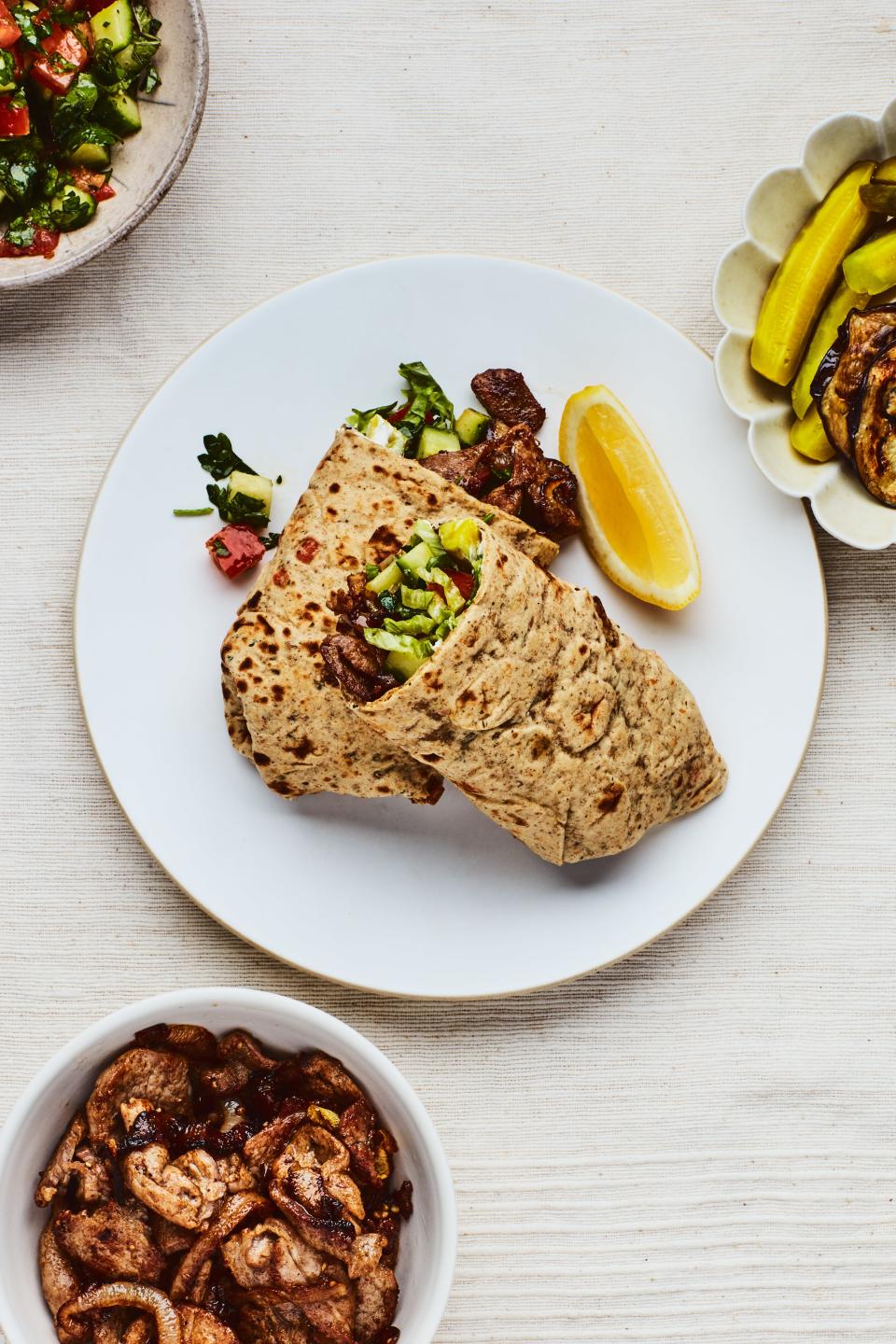 Wrap cooked pork strips in flatbread with hummus, cucumbers, pickles, and shredded lettuce.