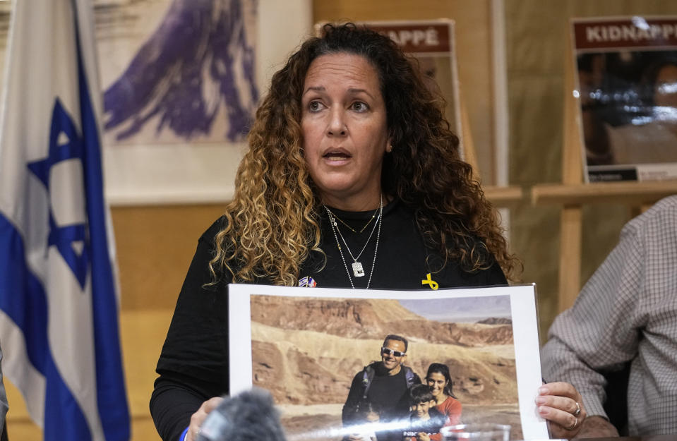 French Israeli Ayala Yanalomi Luzon, holds a picture of her brother who was abducted by Hamas, calls for the release of hostages who were kidnapped on Oct. 7, 2023 during a media conference in Paris, Tuesday, Feb. 2024. (AP Photo/Michel Euler)