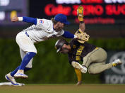 Chicago Cubs second baseman Nico Hoerner, left, catches San Diego Padres' Tyler Wade, right, who was trying to steal second during the eighth inning of a baseball game Monday, May 6, 2024, in Chicago. (AP Photo/Erin Hooley)