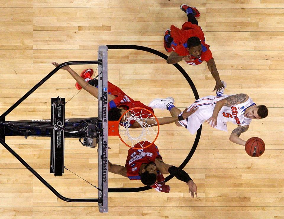 Florida Gators guard Scottie Wilbekin (5) makes a shot down the middle of the lane over Dayton Flyers forward Devon Scott (40) and forward Devin Oliver (5) during the second half of the Elite Eight on Saturday, March 29, 2014 in Memphis, Tenn. Florida defeated Dayton 62-52 to advance to the Final Four.