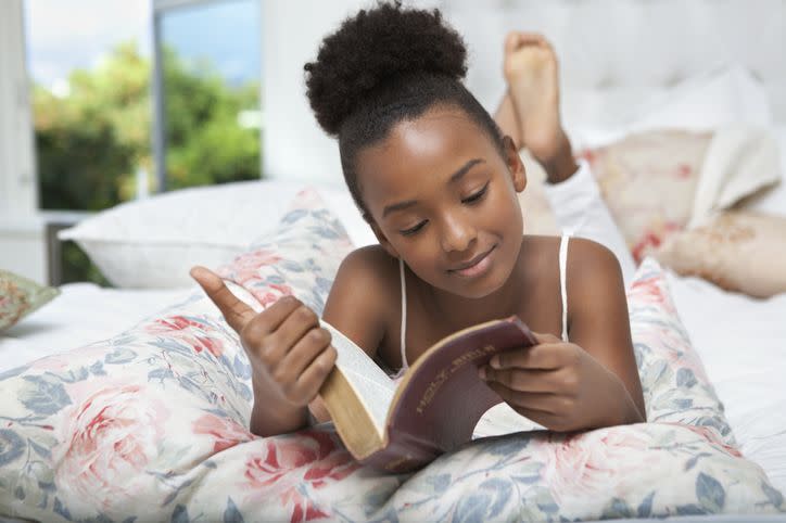 girl reading bible in bed