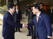 In this photo released by the South Korean Unification Ministry, South Korean chief delegate Kim Kyou-hyun, right, welcomes his North Korean counterpart Won Tong Yon upon arrival at the border village of Panumjom, South Korea, Friday, Feb. 14, 2014. The rival Koreas sat down Friday for a second round of talks this week at a border village as the North's calls for a delay of annual South Korea-U.S. military drills threaten plans for the resumption of emotional reunions of war-divided families. (AP Photo/South Korean Unification Ministry)