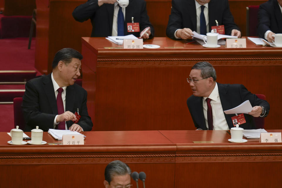 Chinese President Xi Jinping, left, talks with Chinese Premier Li Qiang during opening session of the National People's Congress (NPC) at the Great Hall of the People in Beijing, China, Tuesday, March 5, 2024. (AP Photo/Ng Han Guan)