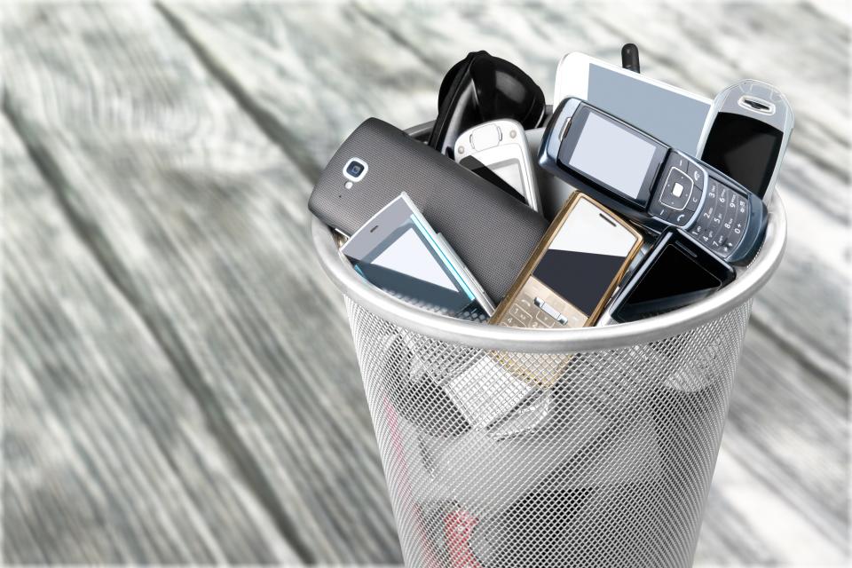 Rubbish bin full of old cellphones
