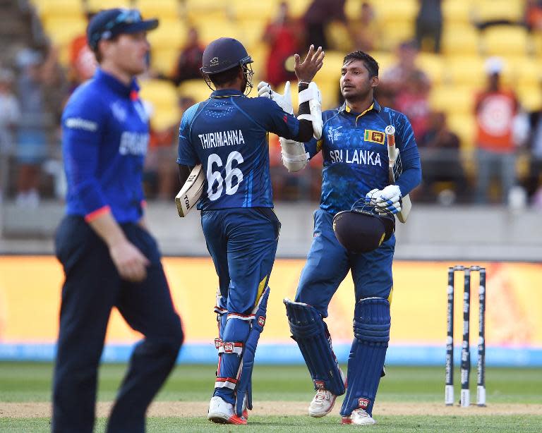 Sri Lanka batsman Kumar Sangakkara (R) is congratulated by teammate Lahiru Thirimanne (C) after scoring a century during their 2015 Cricket World Cup Group A match in Wellington on March 1, 2015