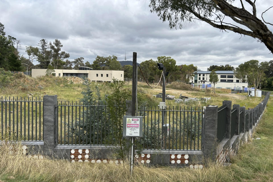 THIS CORRECTS THE PHOTOGRAPHER'S NAME TO MCGUIRK - An unoccupied building, left, sits on the grounds of a proposed new Russian embassy, across from another building, right, that is part of the Chinese embassy near the Australian Parliament in Canberra, Feb. 28, 2023. Australia's House of Representatives passed legislation Thursday, June 15, 2023, to prevent Russia from building a new embassy near Parliament House on security grounds. (AP Photo/Rod McGuirk)