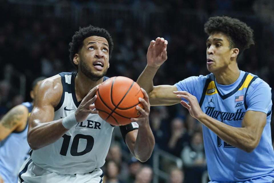 Butler's Bryce Nze (10) goes to the basket against Marquette's Oso Ighodaro (13) during the first half of an NCAA college basketball game, Saturday, Feb. 12, 2022, in Indianapolis. (AP Photo/Darron Cummings)