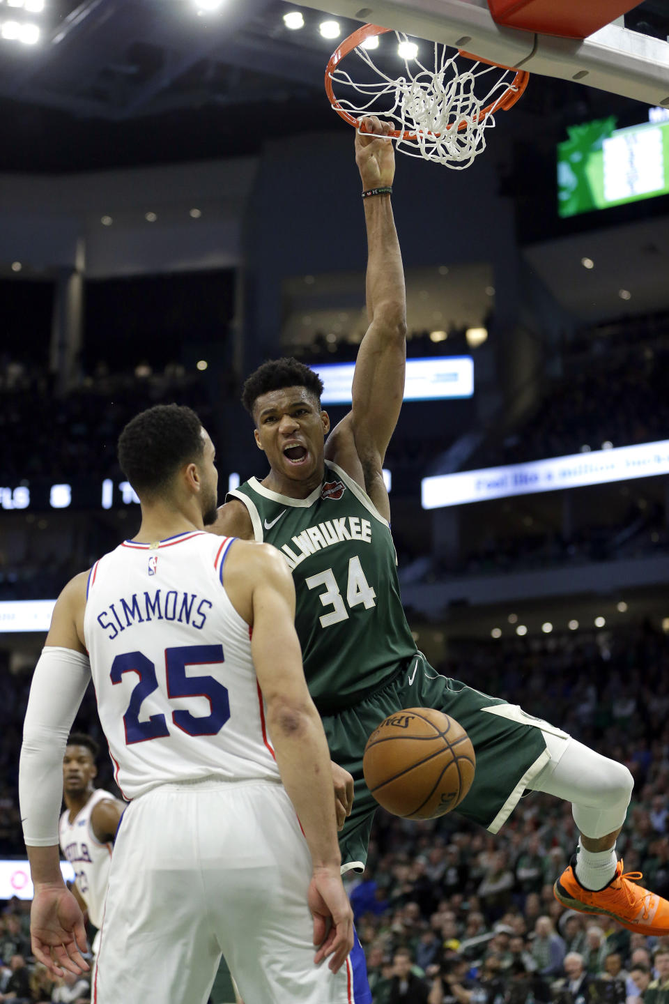 Milwaukee Bucks' Giannis Antetokounmpo (34) dunks after being fouled by Philadelphia 76ers' Ben Simmons (25) during the second half of an NBA basketball game Sunday, March 17, 2019, in Milwaukee. The 76ers won 130-125. (AP Photo/Aaron Gash)