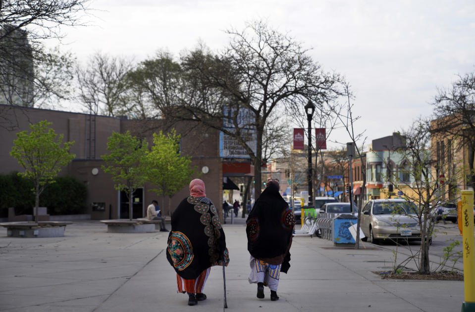 Women walk down a street in the predominantly Somali neighborhood of Cedar-Riverside in Minneapolis on Thursday, May 12, 2022. (AP Photo/Jessie Wardarski)