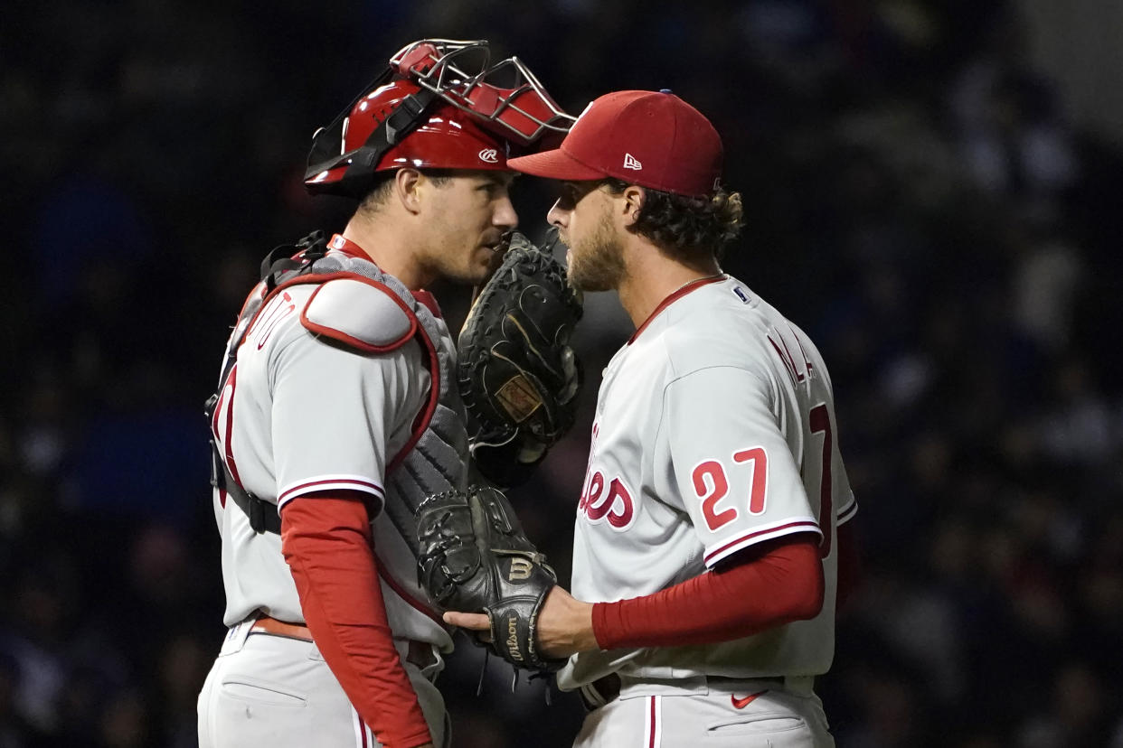 Phillies catcher J.T. Realmuto talks with starting pitcher Aaron Nola during a loss to the lowly Cubs Wednesday night. (AP Photo/Charles Rex Arbogast)