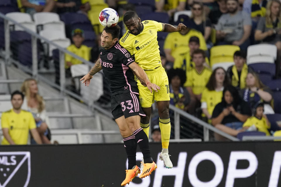 Inter Miami defender Franco Negri (33) heads the ball past Nashville SC defender Shaq Moore, right, during the first half of an MLS soccer match Wednesday, May 17, 2023, in Nashville, Tenn. (AP Photo/George Walker IV)