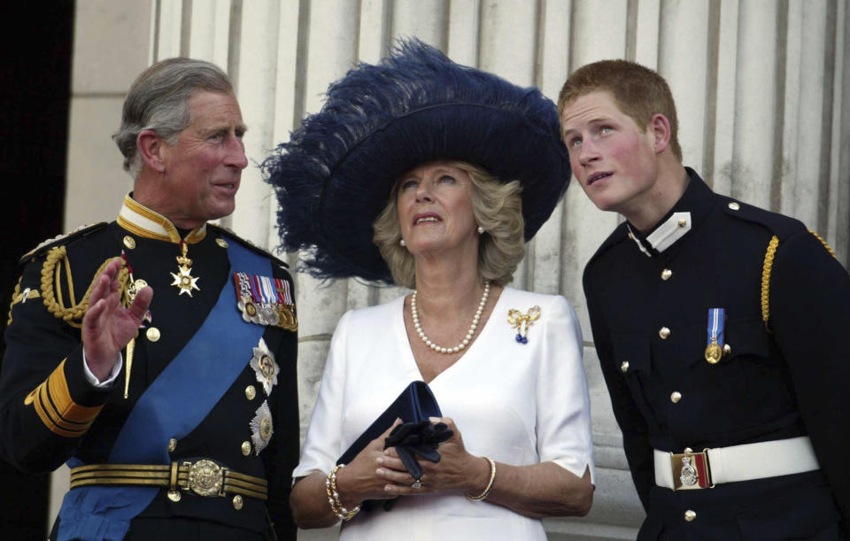 FILE - Britain's Prince Charles, Camilla, Duchess of Cornwall and Prince Harry, from left, watch as a Lancaster bomber drops one million poppies over The Mall, marking the end of WWII, from the balcony of Buckingham Palace, London, Sunday July 10, 2005. Britain's queen consort, Camilla, has come a long way. On May 6, she will be crowned alongside her husband and officially take her first turns on the world stage as Queen Camilla. It’s been a remarkable and painstakingly slow transformation over five decades. (James Vellacott, Pool Photo via AP, File)