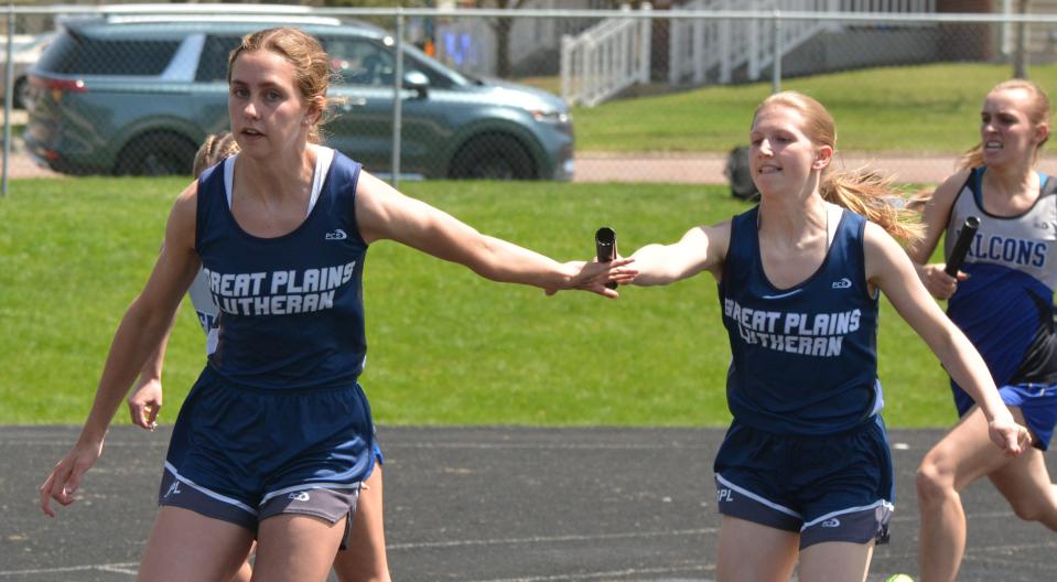 Great Plains Lutheran's Kyrie Roberts (right) passes the baton to teammate Kate Holmen during the girls' 800-meter relay Tuesday during the Eastern Coteau Conference track and field meet at Allen Mitchell Field. GPL won the race.