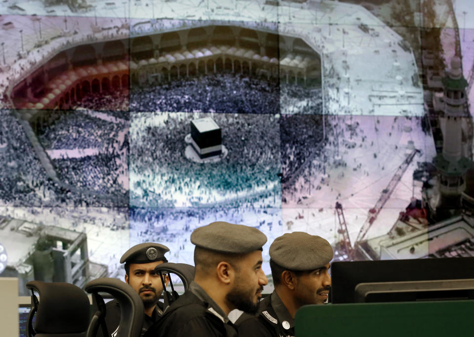 Saudi police officers monitor screens displaying the Grand Mosque, at the 911 monitoring center, ahead of the Hajj pilgrimage in the Muslim holy city of Mecca, Saudi Arabia, Tuesday, Aug. 6, 2019. The hajj occurs once a year during the Islamic lunar month of Dhul-Hijja, the 12th and final month of the Islamic calendar year. (AP Photo/Amr Nabil)