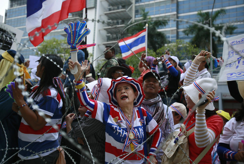 Anti-government protesters shout slogans demanding Thai Prime Minister Yingluck Shinawatra to step down during a protest outside her temporary office in the building of the Permanent Secretary of Defense in northern Bangkok, Thailand, Wednesday, Feb. 19, 2014. The protesters surrounded Yingluck's temporary office to demand her resignation a day after clashes. (AP Photo/Wally Santana)