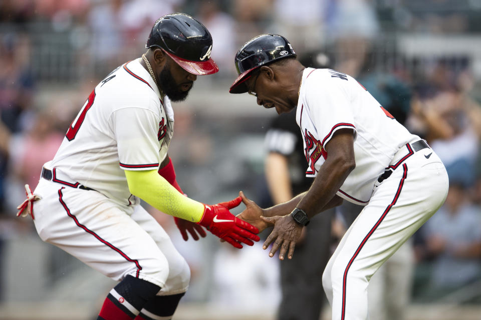 Atlanta Braves' Marcell Ozuna reacts with third base coach Ron Washington after his solo home run hit in the fourth inning of a baseball against the Miami Marlins, Sunday, Sept. 4, 2022, in Atlanta. (AP Photo/Hakim Wright Sr.)