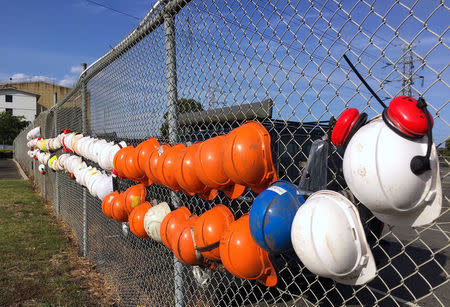 Worker's safety hats adorn the fence surrounding the Hazelwood Power Station before its closure on March 31 in the town of Hazelwood, located in the Latrobe Valley, south-east of Melbourne in Australia, March 29, 2017. REUTERS/Sonali Paul