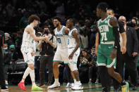 Charlotte Hornets' LaMelo Ball, left, Miles Bridges (0) and Terry Rozier celebrate as Boston Celtics' Dennis Schroder looks back after they beat the Celtics in an NBA basketball game Wednesday, Jan. 19, 2022, in Boston. (AP Photo/Winslow Townson)