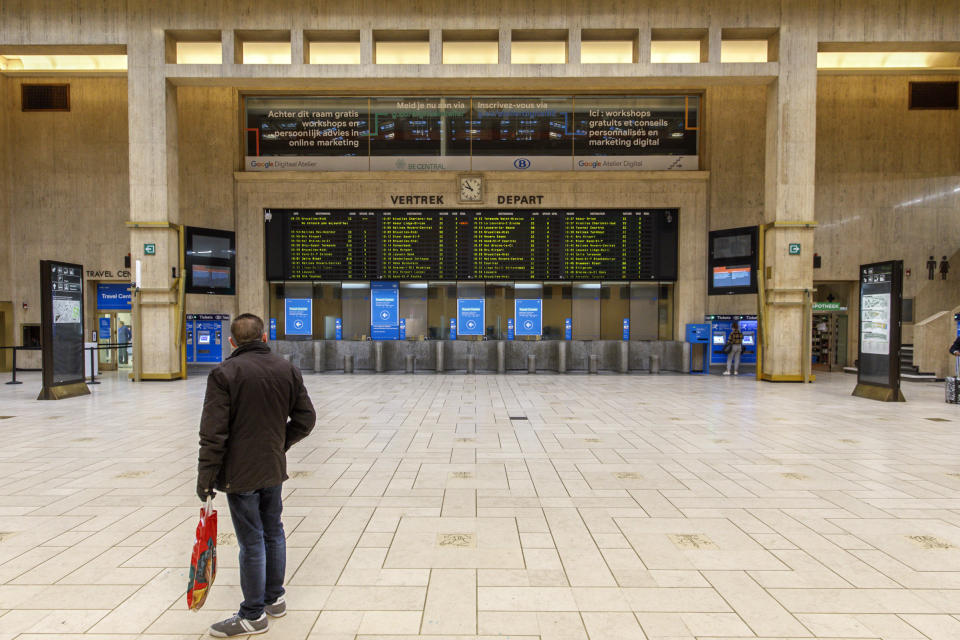 A man looks at departure boards at the main hall of the nearly empty Central train station in Brussels, Monday, March 16, 2020. Belgium has closed schools, restaurants and bars as well as cancelled cultural and sporting events in an effort to stem the spread of the coronavirus. For most people, the coronavirus causes only mild or moderate symptoms, such as fever and cough. For some, especially older adults and people with existing health problems, it can cause more severe illness, including pneumonia. (AP Photo/Olivier Matthys)