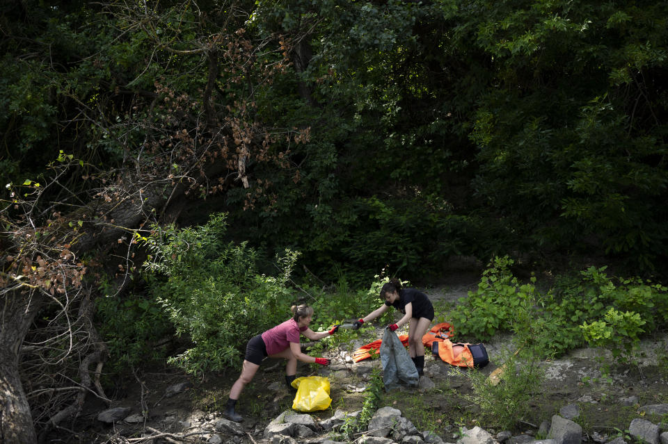 Volunteers collect rubbish from the banks of Tisza River near Tiszaroff, Hungary, Wednesday, Aug. 2, 2023. Since its start in 2013, participants in the annual Plastic Cup competition — which offers a prize for those who collect the most trash each year — have gathered more than 330 tons (around 727,000 pounds) of waste from the Tisza and other Hungarian waters. (AP Photo/Denes Erdos)