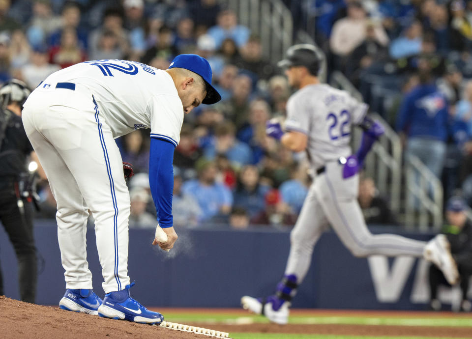 Toronto Blue Jays pitcher Paolo Espino, front left, reacts as Colorado Rockies' Nolan Jones (22) rounds the bases on a solo home run in fifth-inning baseball game action in Toronto, Friday, April 12, 2024. (Frank Gunn/The Canadian Press via AP)