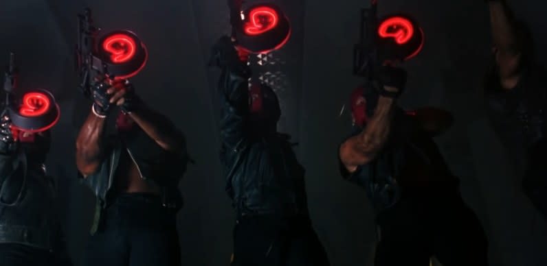 Two-face goons hold light-up guns