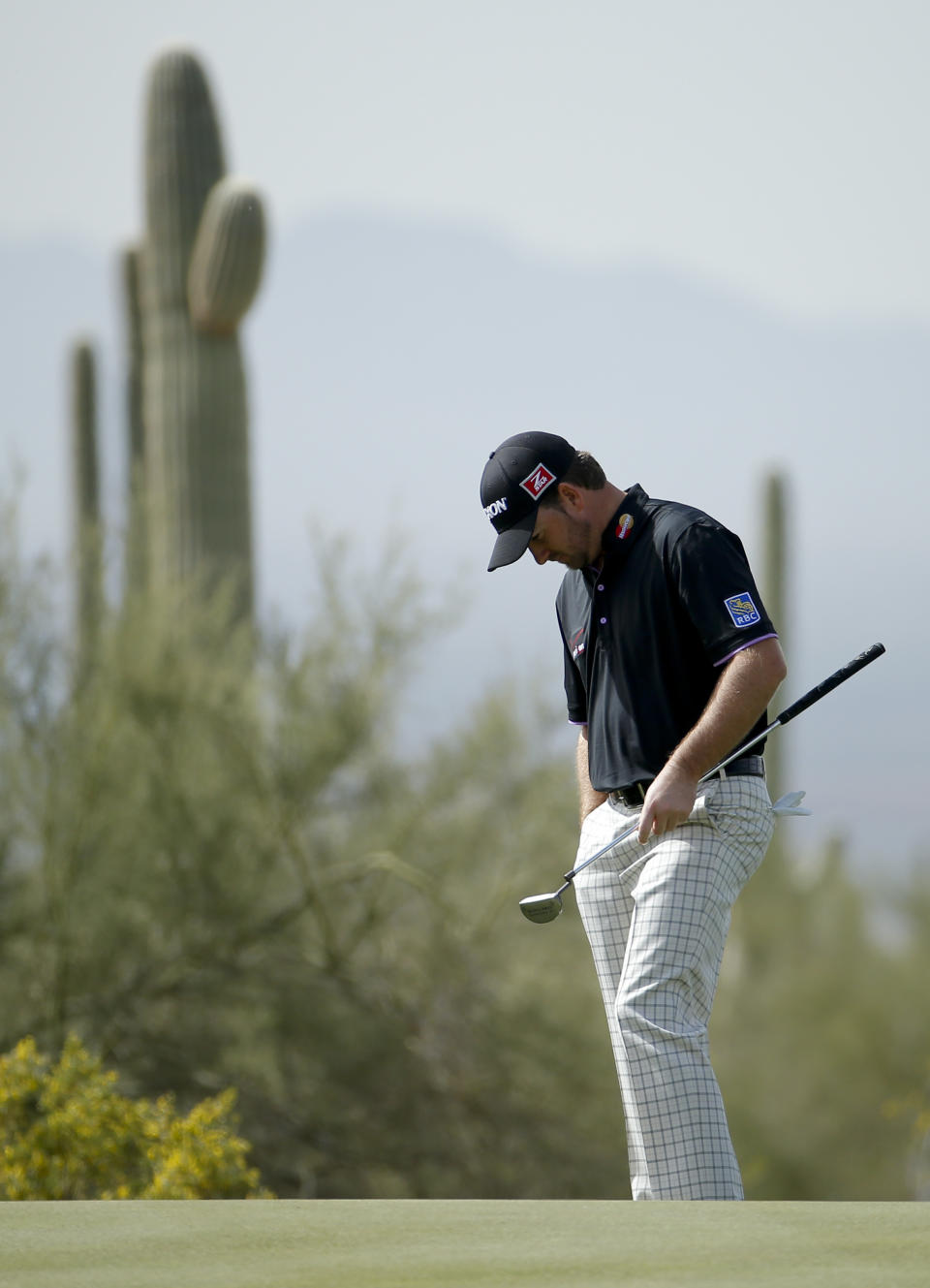 Graeme McDowell, of Northern Ireland, reacts to a putt on the first hole in his match against Hunter Mahan during the third round of the Match Play Championship golf tournament on Friday, Feb. 21, 2014, in Marana, Ariz. (AP Photo/Matt York)