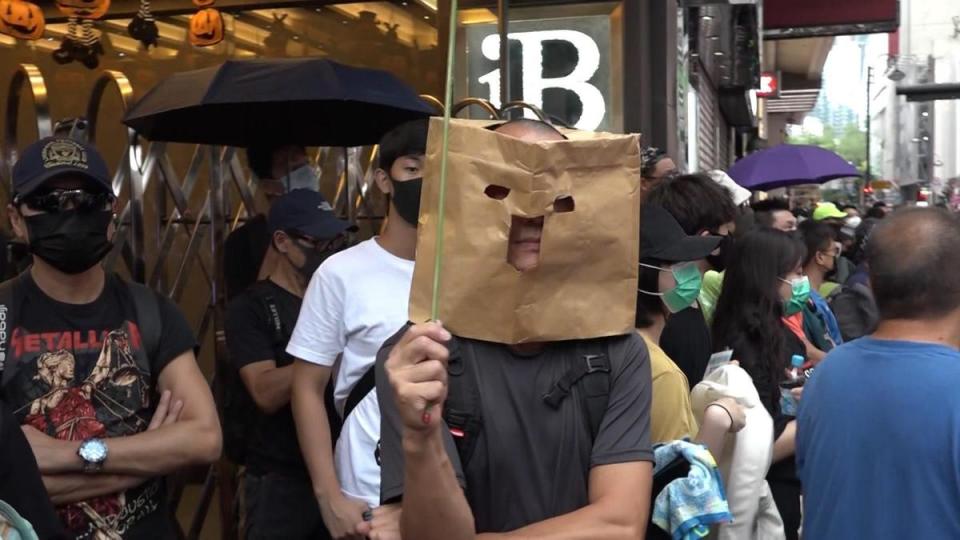 不少參與遊行的人，不畏新法上路，仍戴上口罩或面罩現身街頭。（翻攝香港電台視像新聞臉書）
