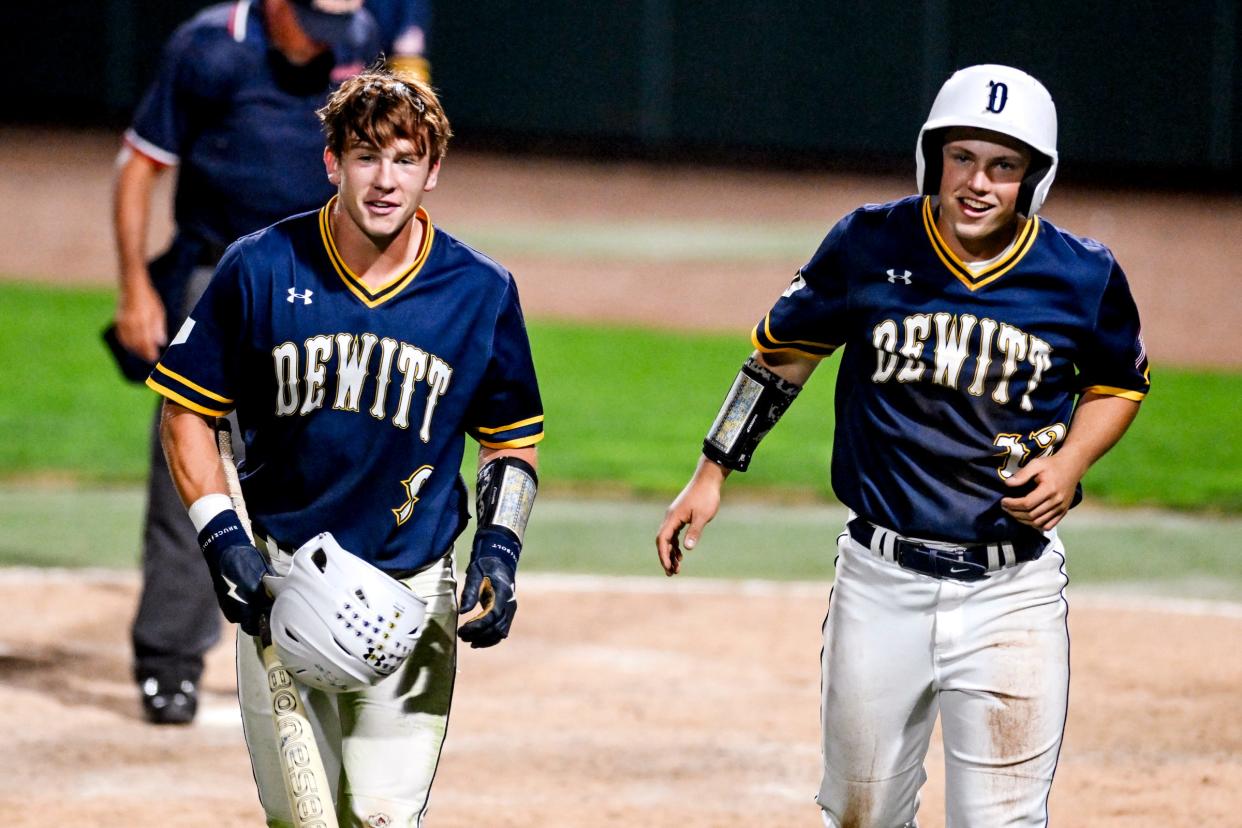 DeWitt's Nathaniel Torrence, right, and Trav Moore, left, celebrate their runs against Mason in the fourth inning on Tuesday, May 21, 2024, during the Diamond Classic at MSU's McLane Stadium in East Lansing