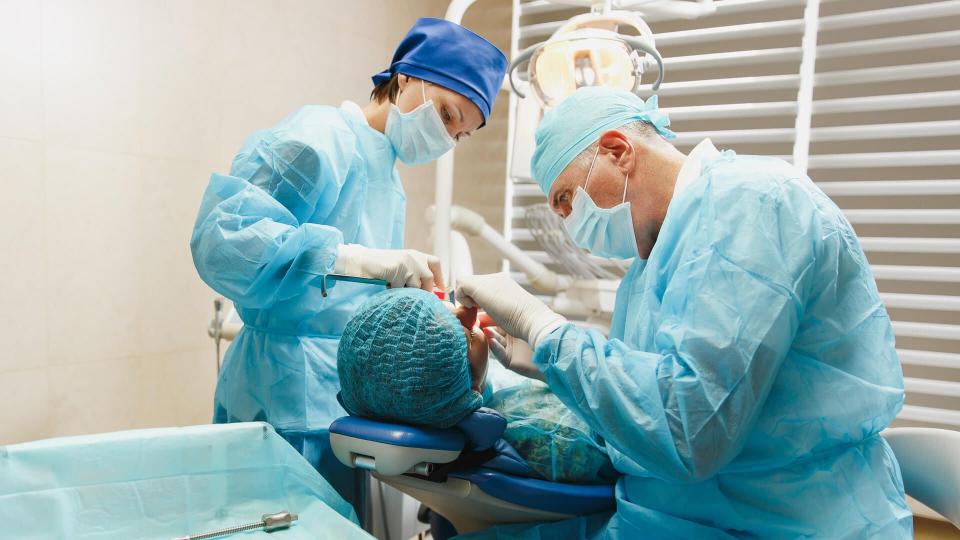 oral surgeon working on patient