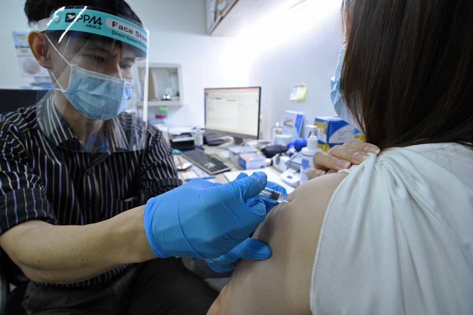 A doctor injects a woman with Sinovac COVID-19 vaccine at a private clinic in Singapore on July 6, 2021. (Photo by Then Chih Wey/Xinhua via Getty Images)