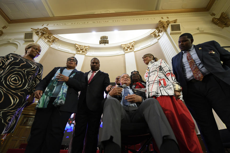 Rev. Jesse Jackson is handed the microphone by his son U.S. Rep. Jonathan Jackson before announcing that he is stepping down as the president at Rainbow PUSH Coalition, Saturday, July 15, 2023, in Chicago. (AP Photo/Paul Beaty)