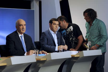 Greece's former prime minister and leader of leftist Syriza party Alexis Tsipras (C) and leader of conservative New Democracy party Evangelos Meimarakis (L) prepare for a political leaders' debate at the headquarters of state broadcaster ERT, in Athens, Greece, September 9, 2015. REUTERS/Michalis Karagiannis