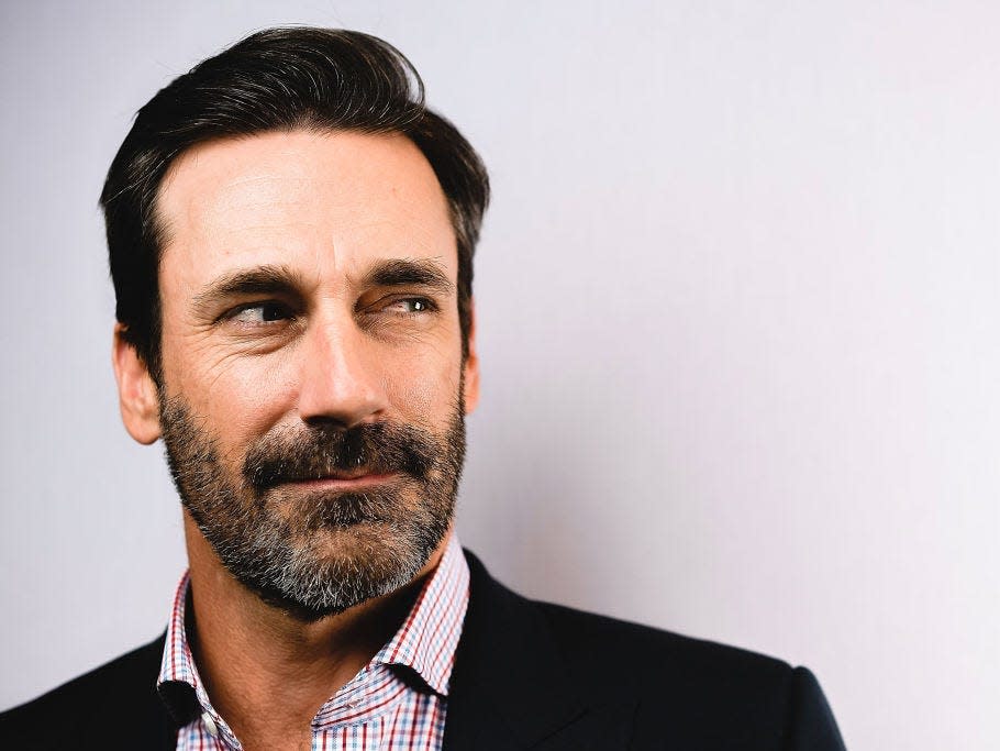 Jon Hamm looks to the side with a thoughtful expression.