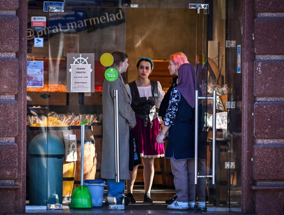 <span class="caption">Everyday Russians, like these people in Moscow, may shoulder much of the burden of the world's economic sanctions aimed at Vladimir Putin and his oligarchs.</span> <span class="attribution"><a class="link " href="https://www.gettyimages.com/detail/news-photo/shop-assistant-speaks-to-customers-in-a-candy-store-in-news-photo/1239387719" rel="nofollow noopener" target="_blank" data-ylk="slk:AFP via Getty Images;elm:context_link;itc:0;sec:content-canvas">AFP via Getty Images</a></span>