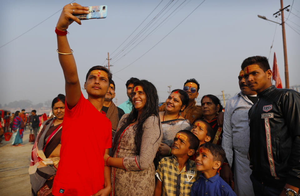 A family takes a selfie after a holy dip at Sangam during Magh mela festival, in Prayagraj, India. Friday, Feb. 19, 2021. Millions of people have joined a 45-day long Hindu bathing festival in this northern Indian city, where devotees take a holy dip at Sangam, the sacred confluence of the rivers Ganga, Yamuna and the mythical Saraswati. Here, they bathe on certain days considered to be auspicious in the belief that they be cleansed of all sins. (AP Photo/Rajesh Kumar Singh)