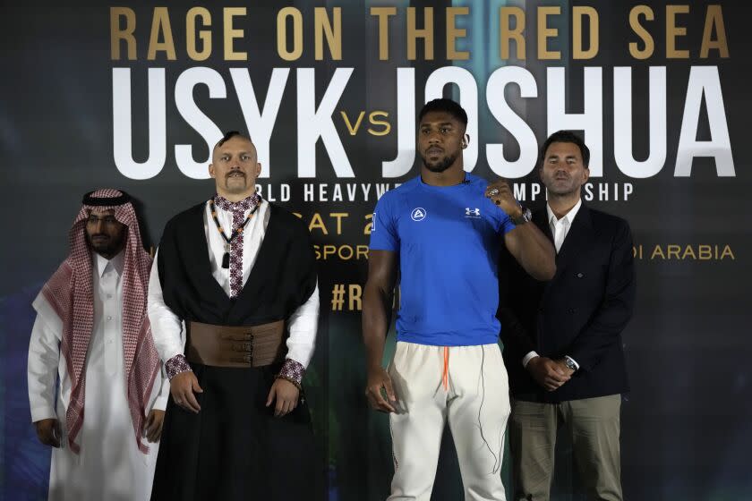 Britain's Anthony Joshua, right, and Ukraine's Oleksandr Usyk pose head-to-head for the media after their press conference in Jeddah, Saudi Arabia, Wednesday, Aug. 17, 2022. Joshua is due to fight defending champion Usyk in a heavyweight boxing rematch in Jeddah on Aug. 20. (AP Photo/Hassan Ammar)