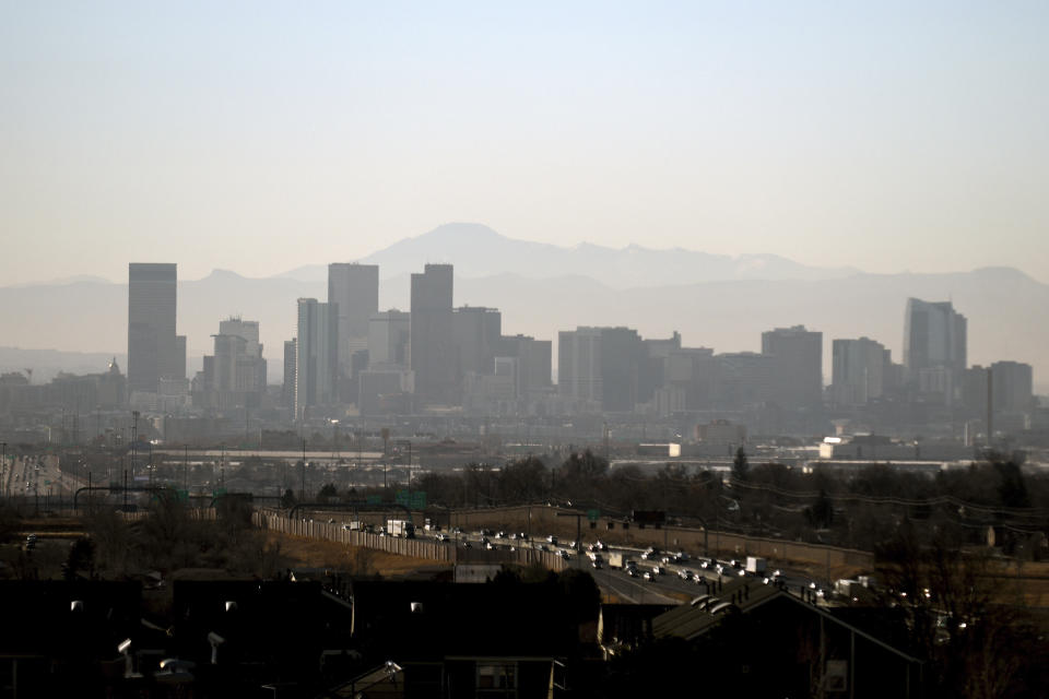 The downtown Denver skyline is seen on Friday, Dec. 3, 2021. The Mile High City has already shattered its 87-year-old record for the latest measurable snowfall set on Nov. 21, 1934, and it's a little more than a week away from breaking an 1887 record of 235 consecutive days without snow. The scenario is playing out across much of the Rocky Mountains, as far north as Montana and in the broader Western United States, which is experiencing a megadrought that studies link to human-caused climate change. (AP Photo/Thomas Peipert)