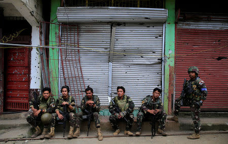 Government soldiers takes a break in front of a damaged building in Sultan Omar Dianalan boulevard at Mapandi district in Marawi city, southern Philippines September 13, 2017. REUTERS/Romeo Ranoco