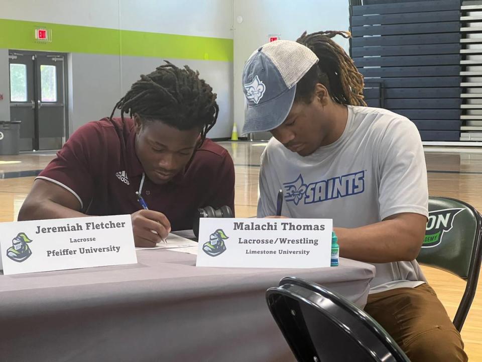 Jeremiah Fletcher (left) and Malachi Thomas (right) sign their ceremonial national letters of intent.